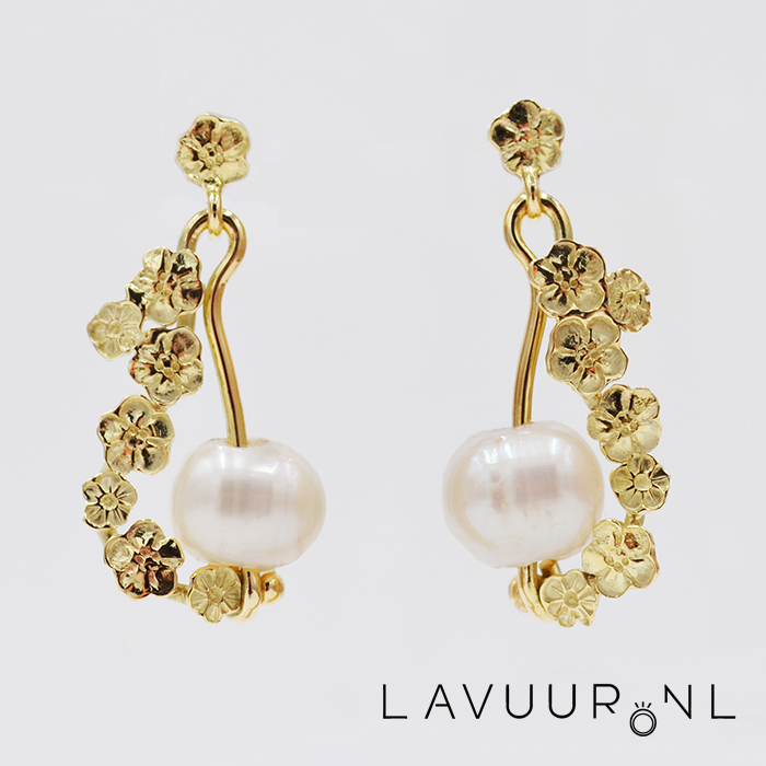 Gouden oorbellen gedecoreerd met gestempelde bloemen die sierlijk langs een grote parel vallen