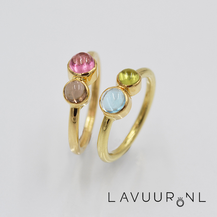 twee gouden ringen, elk met twee ronde stenen van verschillende grootte, de linker met toermalijn en rookkwarts, de rechter met topaas en peridoot