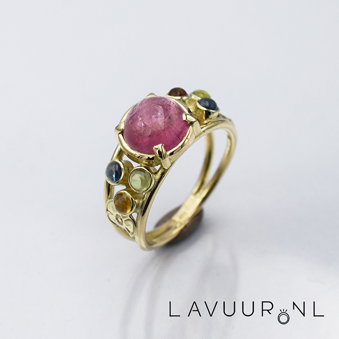 Gouden ring met verschillende ronde edelstenen, een grote ronde toermalijn in het midden en kleinere gekleurde edelstenen er omheen