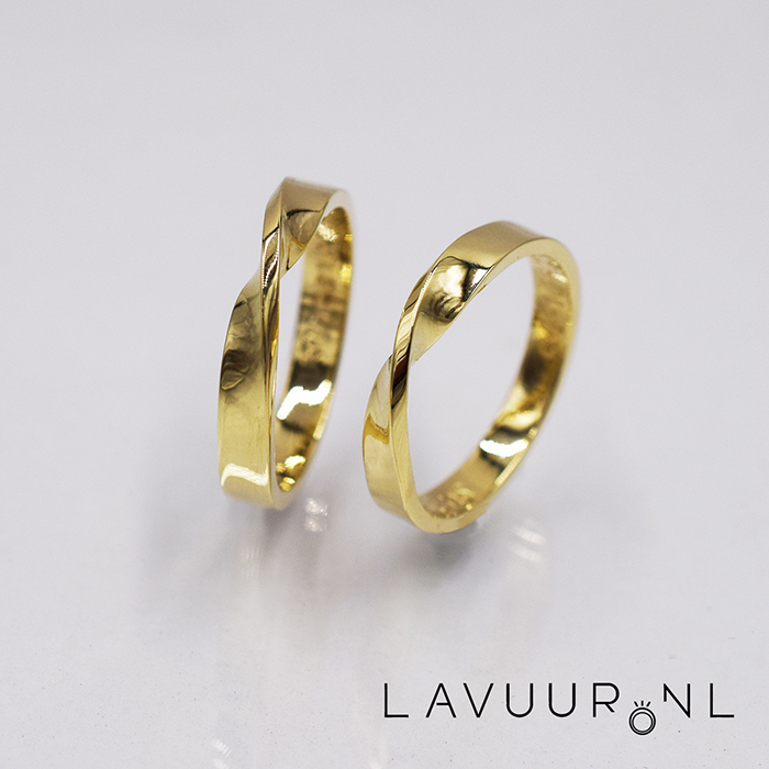 twee gouden trouwringen, beiden gemaakt van rechthoekige gladde band, die beiden een Möbius ring vormen