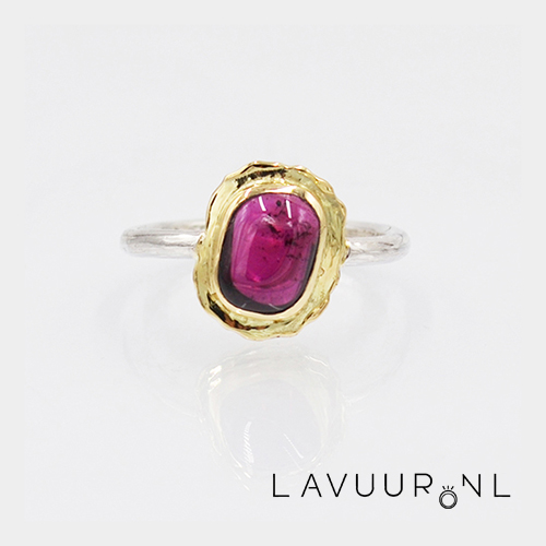 zilveren ring met ronde band met in het midden een brede, onregelmatige gouden zetting die een beetje scheef staat met een gladde onregelmatige granaat