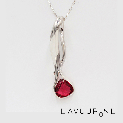 zilveren hanger van uitgesmeed zilver als een bladvorm met aan het uiteinde een peervormige rubelliet